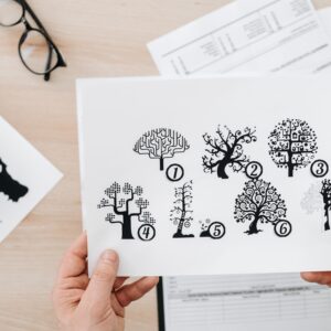 Close-up showing hands holding paper with tree test illustration for psychological assessment.